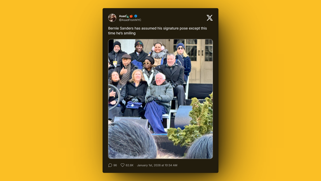 Bernie Sanders seated outdoors with his signature pose, smiling and wearing a blue blanket